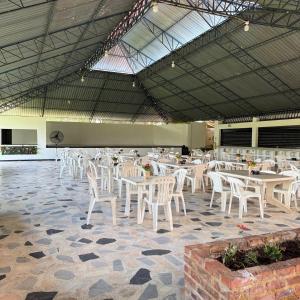 a dining room with white tables and white chairs at Lagos de Samarcanda in Cumaral