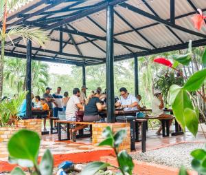 a group of people sitting at tables in a pavilion at Lagos de Samarcanda in Cumaral