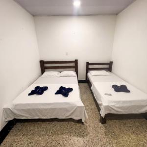 two beds in a room with blue bows on them at Lagos de Samarcanda in Cumaral