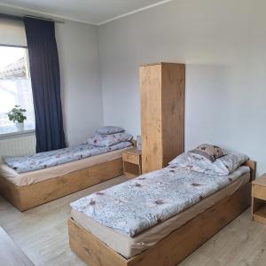 a bedroom with two beds and a window at Noclegi Arka in Osiek