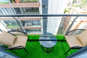 a balcony with two chairs and a glass table at The Residence -Juction Mall in Nairobi