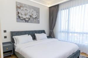 a bedroom with a large bed and a window at The Residence -Juction Mall in Nairobi
