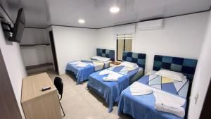 a room with two beds and a desk with a computer at Finca Ecoturística Canaguaros in Tauramena
