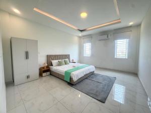 a bedroom with a bed and a cabinet in it at Spacious 5BR Townhouse in Central Phnom Penh in Phnom Penh