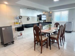 a dining room with a table and chairs and a kitchen at Spacious 5BR Townhouse in Central Phnom Penh in Phnom Penh