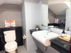 a bathroom with a white toilet and a sink at Spacious 5BR Townhouse in Central Phnom Penh in Phnom Penh