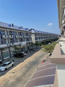 an empty street with cars parked in front of buildings at Spacious 5BR Townhouse in Central Phnom Penh in Phnom Penh