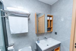 a bathroom with a sink and a toilet and a mirror at The Residence -Juction Mall in Nairobi +12 photos