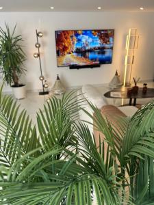 a living room with a couch and some plants at Escale 53 A 5 min aéroport Orly in Athis-Mons