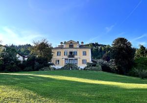 a large house on top of a grassy field at Villa CALVI Lago Maggiore in Premeno