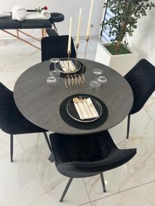 a black dining table with black chairs and a black plate at Escale 53 A 5 min aéroport Orly in Athis-Mons
