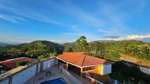a view of a house with a roof at Finca los Bohíos in Santa Rosa de Cabal
