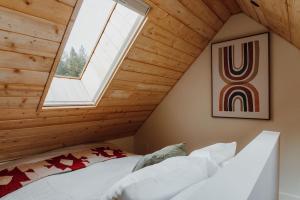 a attic bedroom with a skylight and a bed at Camp Alta in Packwood