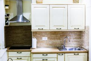a kitchen with white cabinets and a sink at Apartment Genius Loci in Split