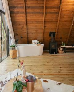 a bath tub in a room with a wooden ceiling at Lohma Nature in Gramado +4 photos