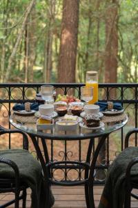 a glass table with food and drinks on it at Lohma Nature in Gramado