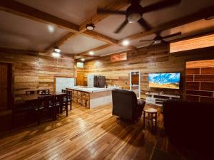a living room with wooden walls and a table and chairs at Hotel Mauka Boutique Villas in Cocles