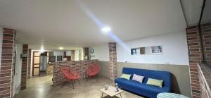 a living room with a blue couch and red chairs at Aloja-T Hostal Jericó in Jericó +15 photos