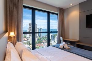 a bedroom with a bed with a large window at Modern Condominium w/ Sea View Pool, Itapema - MHFB in Itapema +146 photos