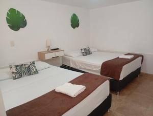 two beds in a room with two at Aloja-T Hostal Jericó in Jericó
