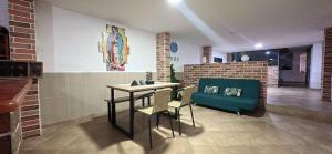 a dining room with a table and chairs and a couch at Aloja-T Hostal Jericó in Jericó