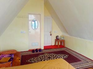 a attic room with a bed and a window at Villa Annisa 2 in Alahanpanjang +2 photos