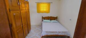 a small bedroom with a small bed and a cabinet at Sítio de Vavá in Gravatá