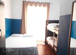 a bedroom with a bed and a window at Hotel e Pousada das Goianas in Santos