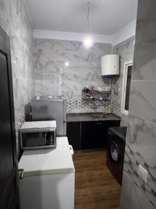 a small kitchen with marble walls and a white refrigerator at Le Nide d'azrou in Azrou