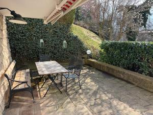 a patio with a table and chairs and a hedge at Gabi`s Villa am Hang in Bad Aibling