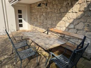 a wooden table and chairs on a stone wall at Gabi`s Villa am Hang in Bad Aibling
