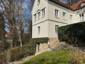 a white house with a clock on the side of it at Gabi`s Villa am Hang in Bad Aibling