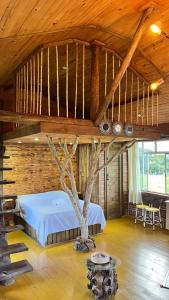 a bedroom with a tree in the middle of it at Studio Rústico - Refúgio Arara Azul in Urubici