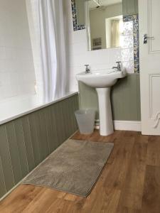 ein Badezimmer mit Waschbecken und Spiegel in der Unterkunft Trezise Cottage in Penzance