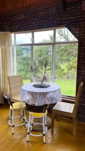 a table and chairs in a room with a window at Studio Rústico - Refúgio Arara Azul in Urubici +23 photos
