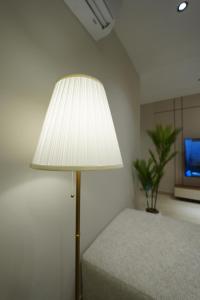a lamp in a room with a bed and a tv at Elite Alsultan in Al Khobar