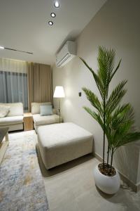 a living room with a palm tree and a couch at Elite Alsultan in Al Khobar