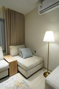 a living room with a couch and a lamp at Elite Alsultan in Al Khobar