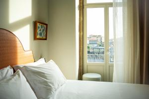 a bedroom with a white bed and a window at The Mila Porto in Porto