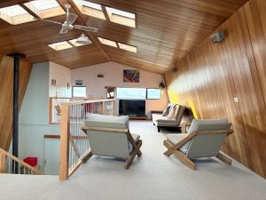 a living room with skylights and chairs in a house at Whangaroa Barn in Whangaroa