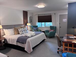 a bedroom with a bed and two chairs and a table at Discovery Inn in Friday Harbor