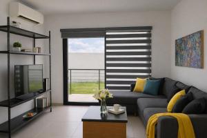 a living room with a couch and a large window at Modern apartment with pool , Riviera Nayarit in Naranjo