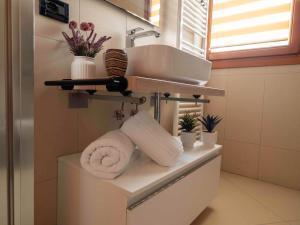 a bathroom with a sink and towels on a shelf at Dimora Porta Vicenza-Montagnana in Montagnana