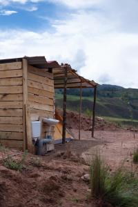 a toilet sitting next to a wooden building at Camping tres nevados in Urubamba