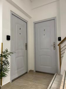 two white doors in a room with a plant at Golden Residence in Vienna