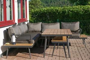 a couch and two tables on a patio at BärenNest Haus in Kirchheim