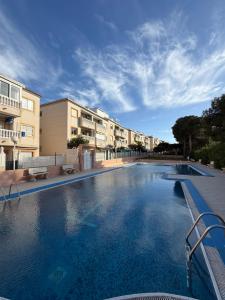 a large swimming pool in front of some buildings at Apartment A&T La Mata in La Mata