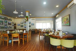 a dining room with tables and chairs in a restaurant at Kakse Teschor Mong Reththy Senchey in Phumĭ Svay Dângkum