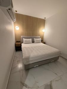a bedroom with a bed with two pillows on it at نزل عطيف - وصول ذاتي in Al Kharābah