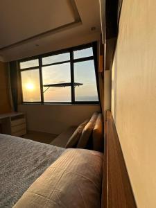 a bedroom with a bed and a window with a plane at Vitória Marina Flats in Salvador +16 photos